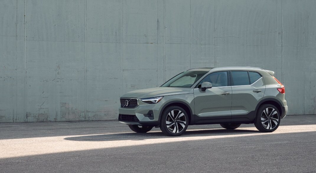2025 Volvo XC40 in grey-green, luxury compact SUV, Scandinavian design on concrete background.