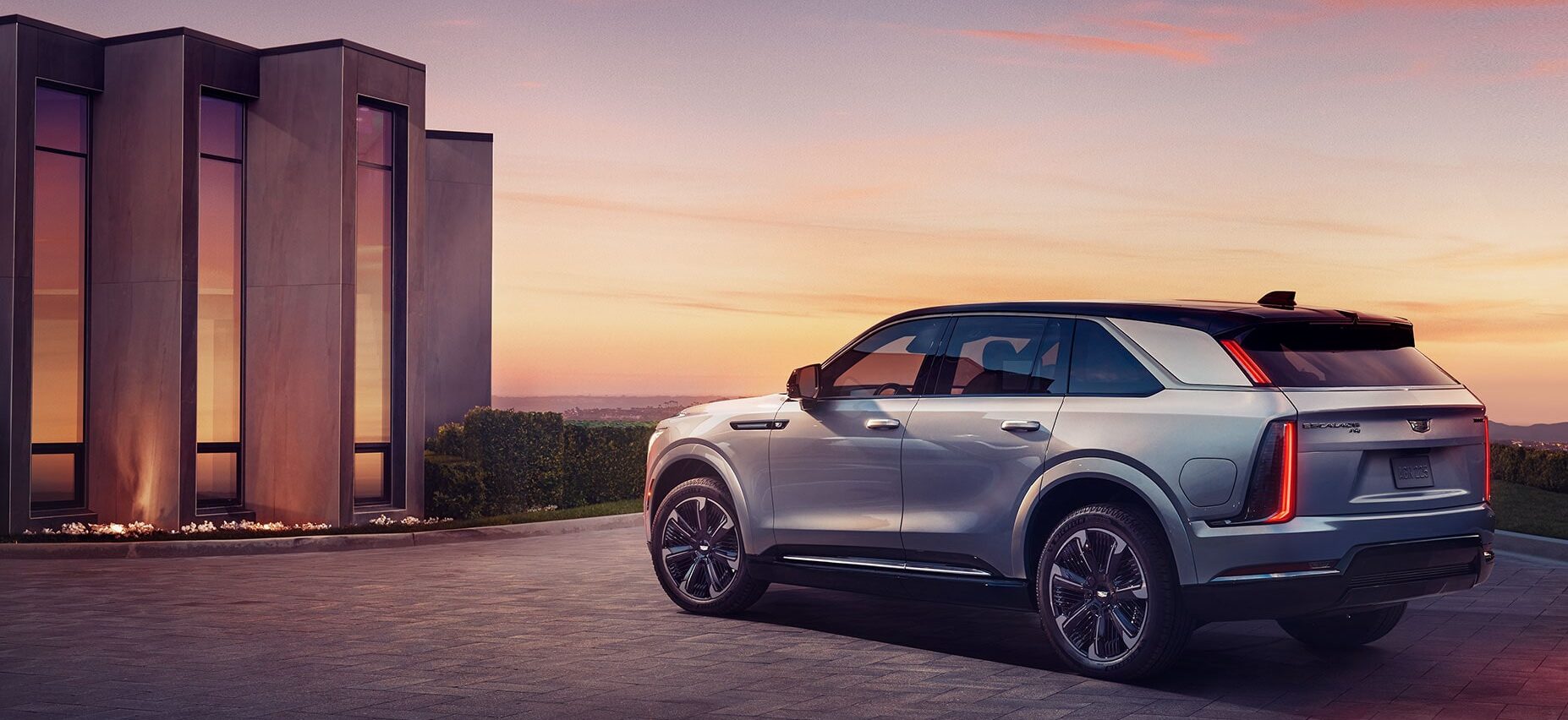 Rear view of the Cadillac Escalade IQ parked in front of a contemporary house