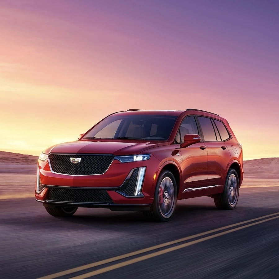 The Cadillac XT6 2025 on a road at sunset.