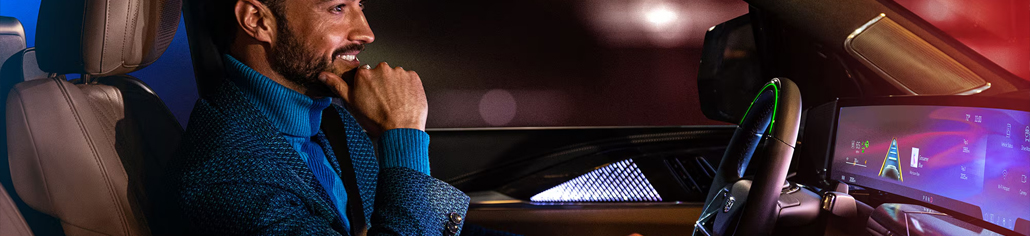 Conducteur Cadillac avec les mains retirées du volant et la barre lumineuse verte Super Cruise allumée
